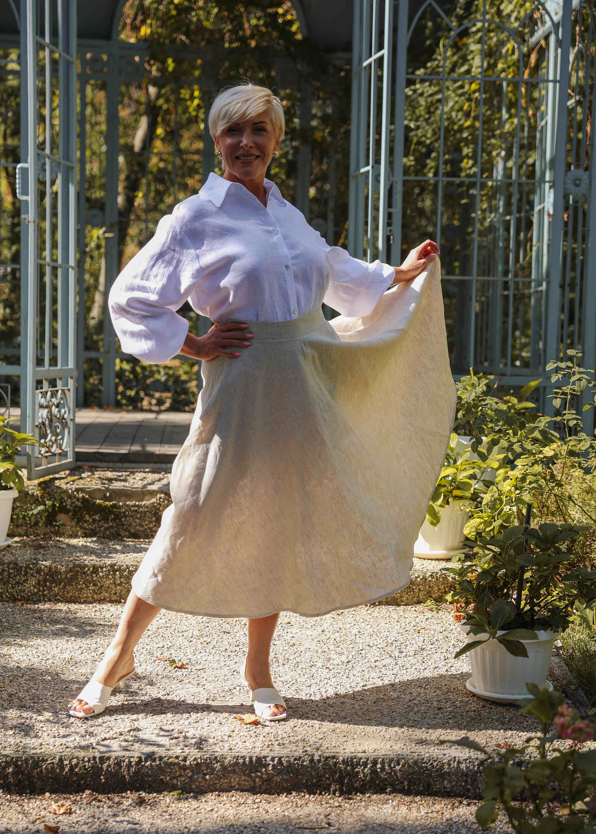 a woman in a white shirt and a beige skirt
