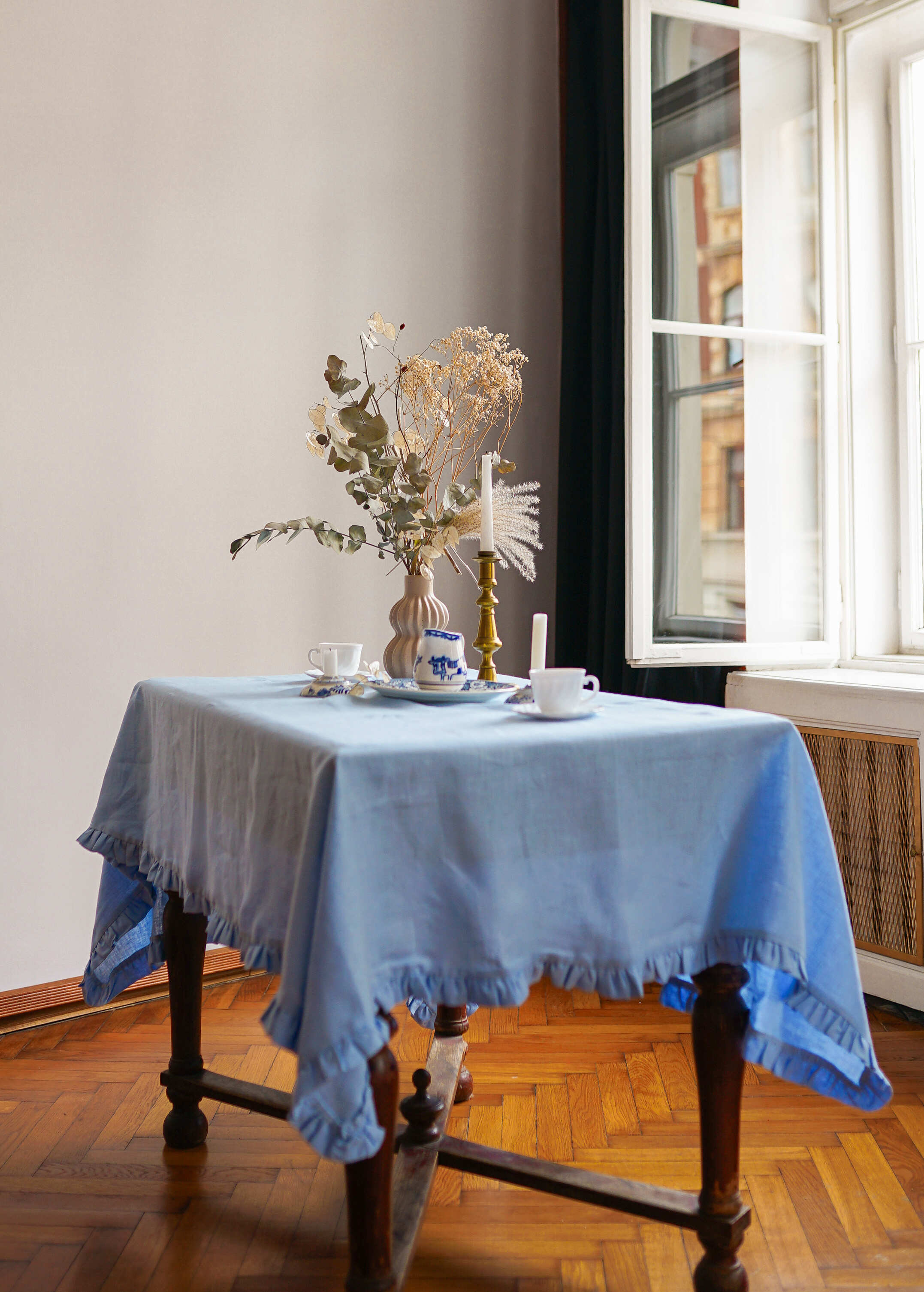 a table with a blue table cloth and a vase with flowers on it