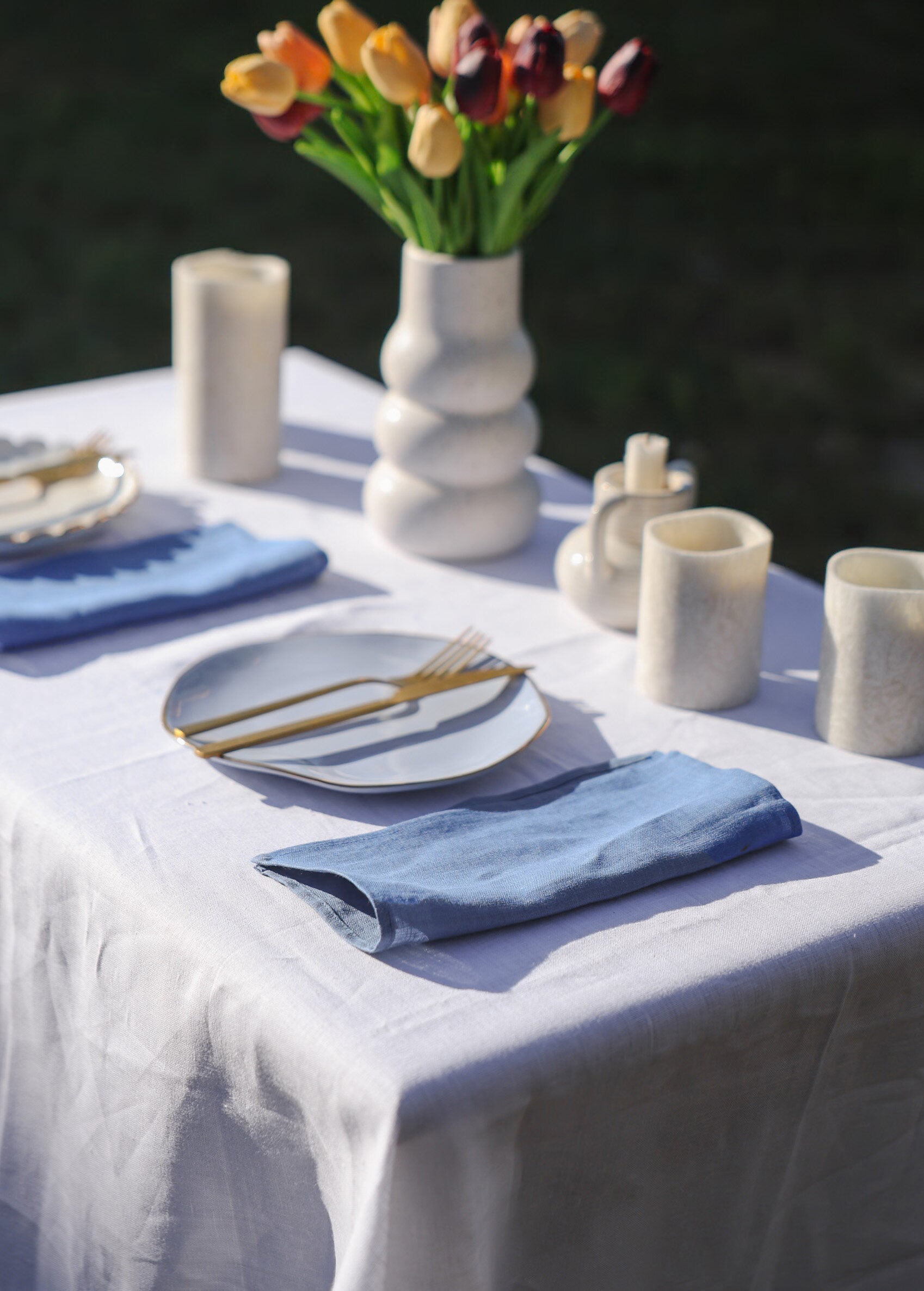 a table with a white table cloth and blue napkins