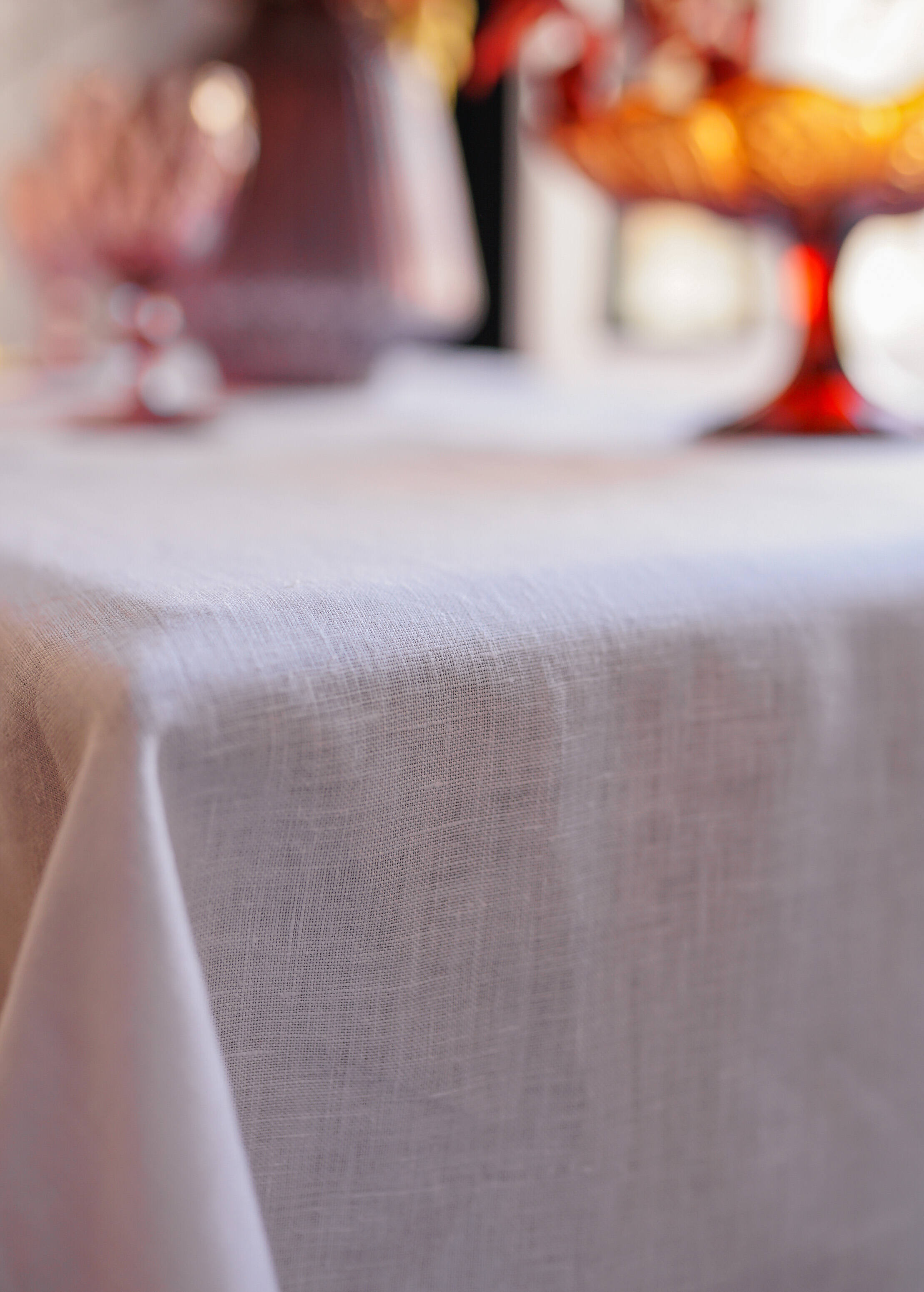 a close up of a table cloth with a vase in the background