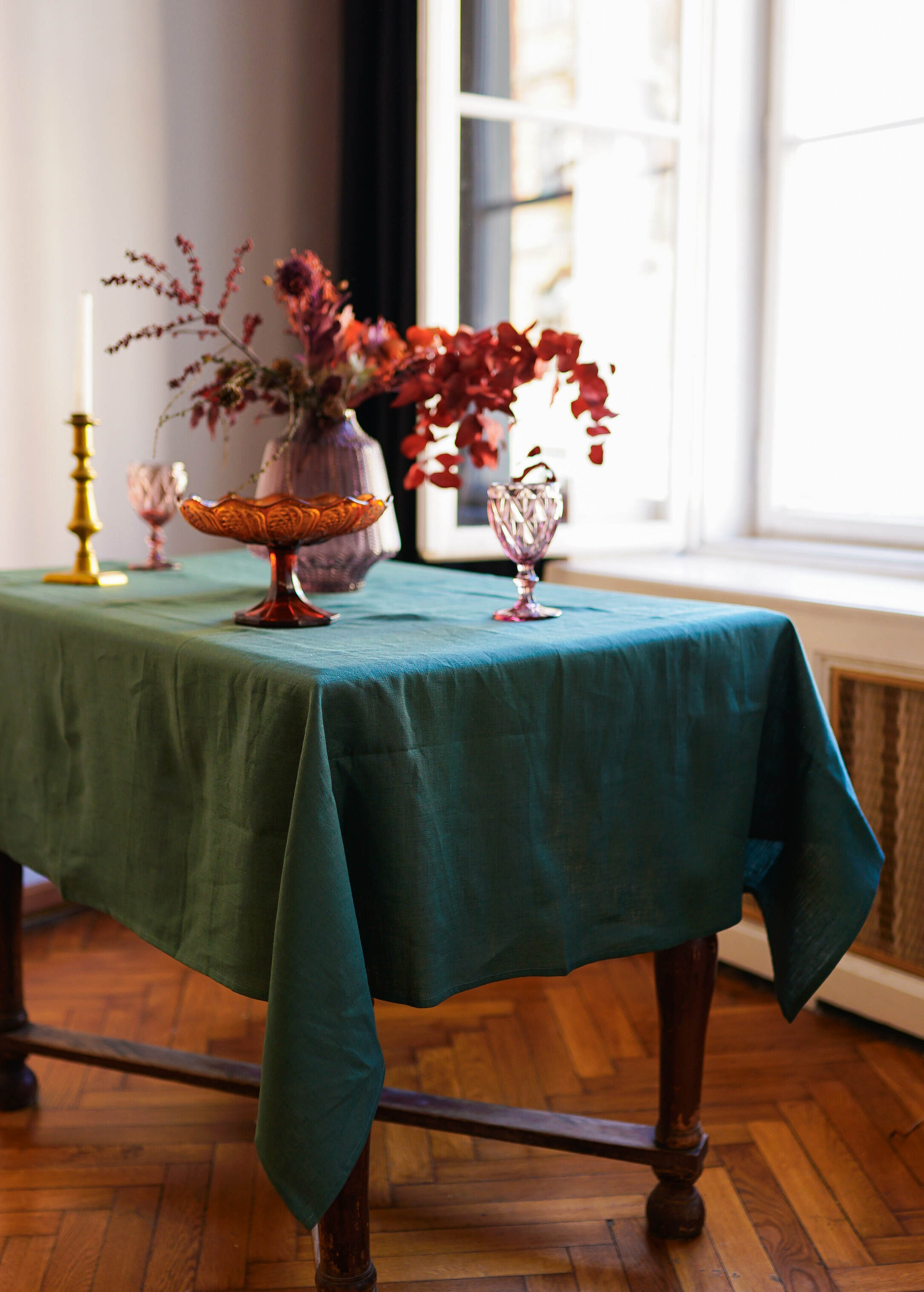 a table with a green tablecloth and a vase of flowers