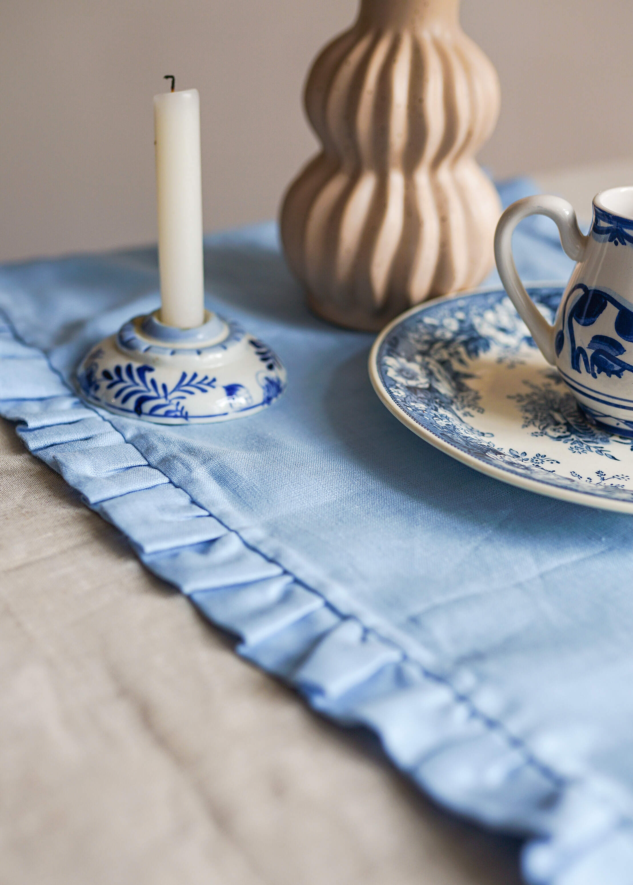 a blue and white table cloth with a tea cup and saucer